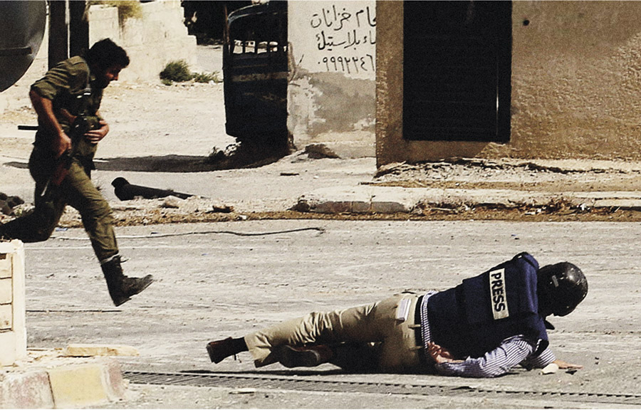 AFP reporter Sammy Ketz drops to the ground to escape sniper fire in Maalula, Syria in September 2013 (Credit: Anwar Amro/AFP/Getty Images)