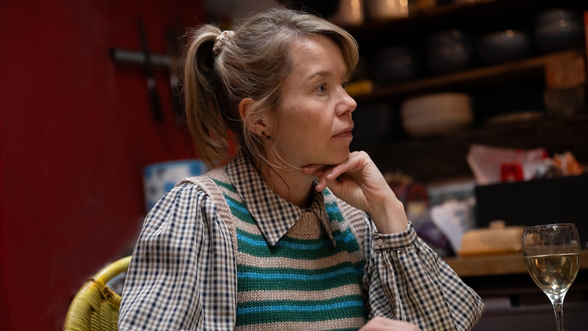 Anna Maxwell Martin sits indoors, in character