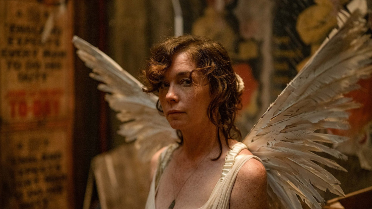 Julianne Nicholson as Kate Galloway looks into the camera, dressed as an angel