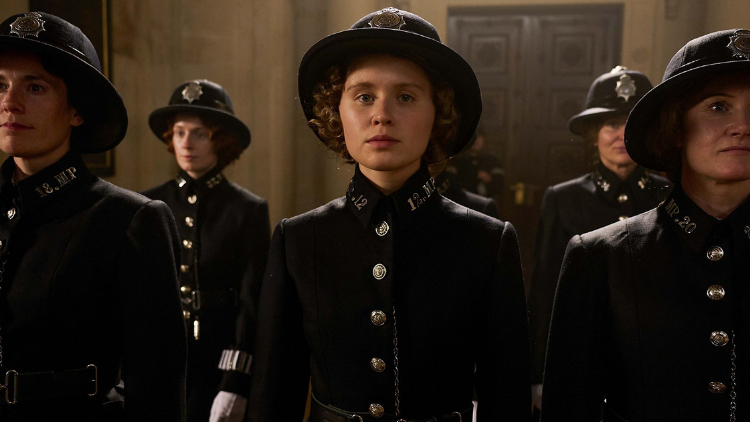 Eliza Scanlen as Violet Davies, in a police officer's uniform, flanked by other officers